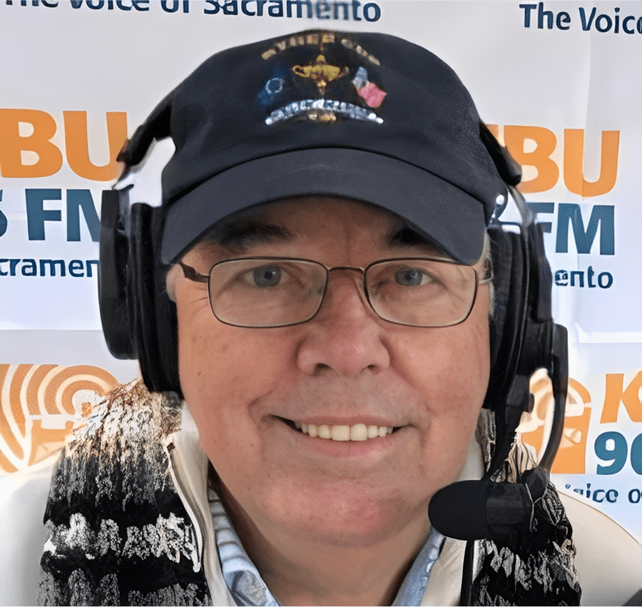 Man wearing headset and cap, smiling