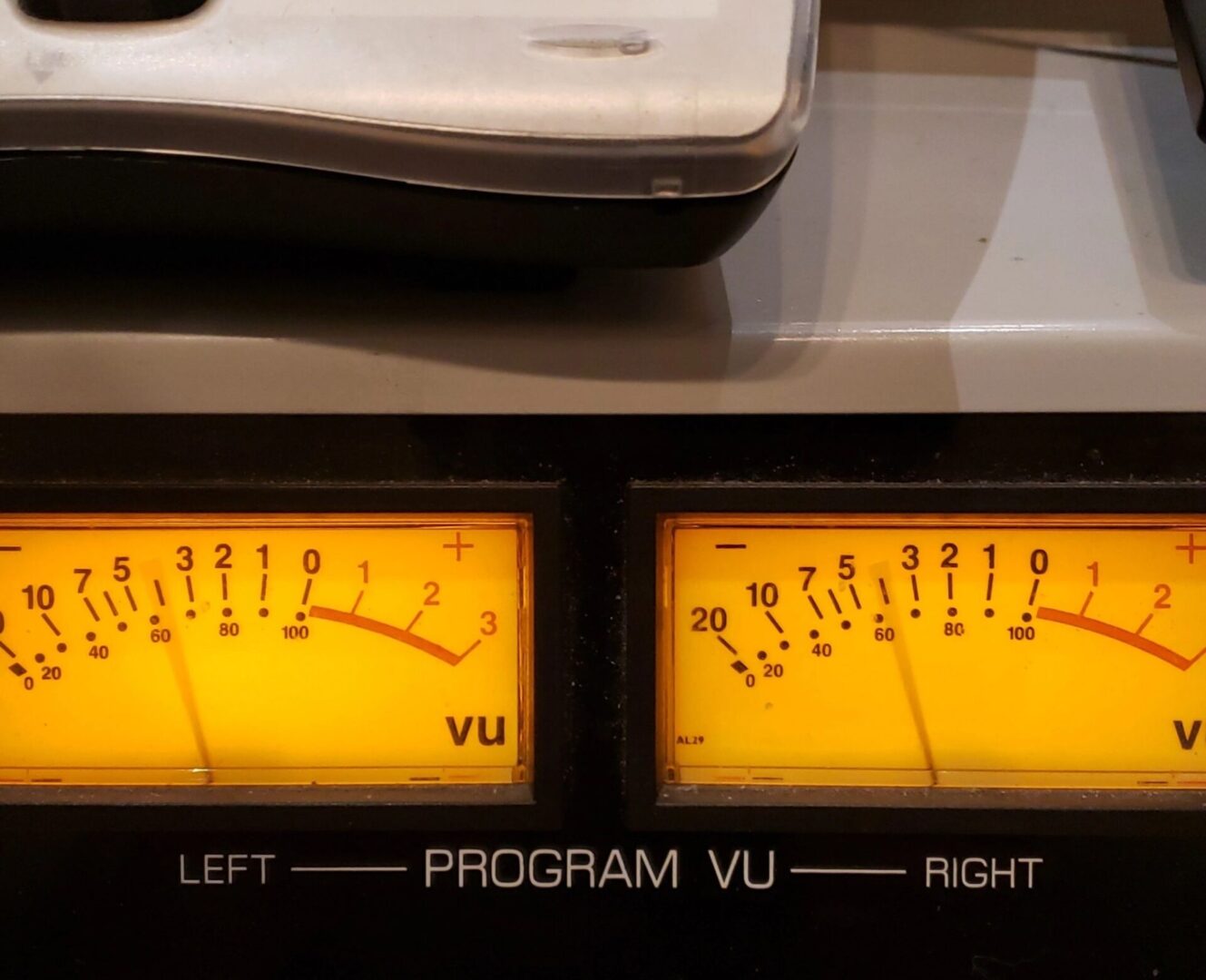 Close-up of vintage audio VU meters displaying program levels for left and right channels.